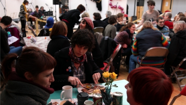 Seated people at a table enjoy brunch at a Bruncheon live music event.