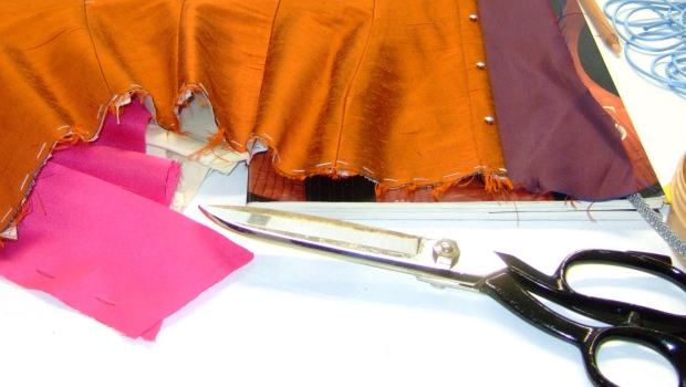 A pair of scissors about to cut a corset