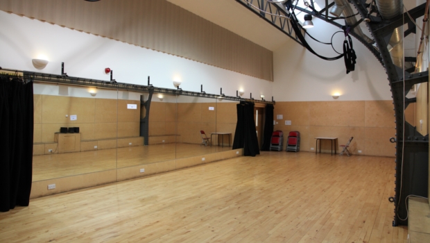 The empty Rehearsal Room at The Out of the Blue Drill Hall has a wooden floor and mirrors, and is ideal for hosting dance and movement classes.