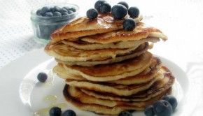 Blueberry pancakes stacked on a plate.