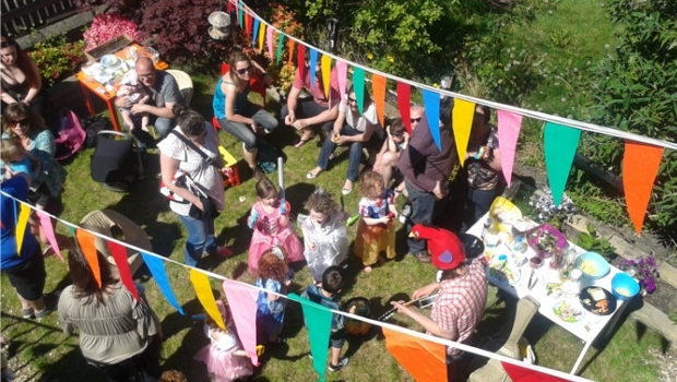 A birdseye view of a happy cowd of adults and children at a Happy Ears event in a park on a sunny day.