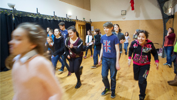 Young actors warm up before a theatre performance rehearsal at The Out of the Blue Drill Hall.