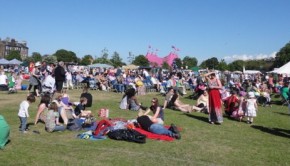 People sit in the sun while Leith Gala Day happens in Leith Links