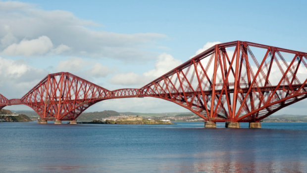 The Forth Rail Bridge is captured with a blue sky behind it.