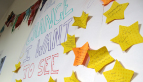 Sticky notes with ideas fill the wall of a poster that reads "Change I Want to See"