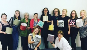 A group of women holding their created lampshades