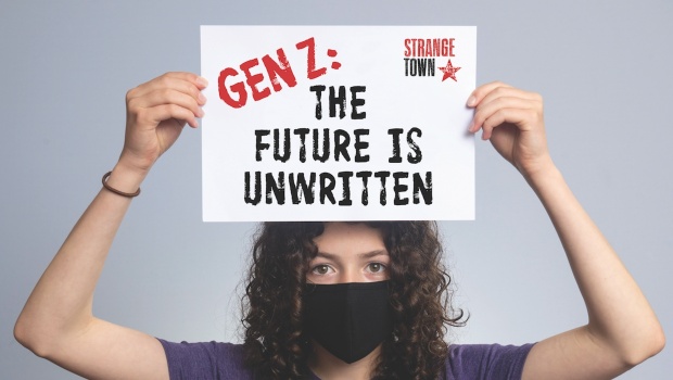 Woman holding a sign reading "Gen Z: The Future is Unwritten"