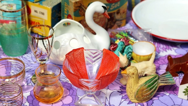 Various ornaments on a table, including a wooden duck, ceramic swan and glass bowls