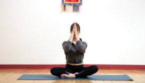 Woman doing yoga on a blue yoga mat